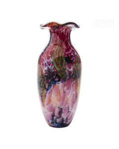 Dekor Deluxe ozka steklena vaza s pisanim vzorcem prelivajočih se barv, zoženo grlo vaze in široka valovita odprtina. Visoka je 44 cm.