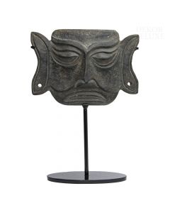 Okultna in zastrašujoča kamnita maska z velikimi očmi in ušesi na črnem kovinskem, ovalnem podstavku. 