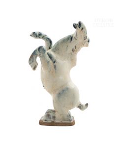 Dekor Deluxe keramična figura konja, ki stoji na zadnjih nogah, bele barve s posameznimi modrimi odtenki, visoka 24 cm, na podstavku.