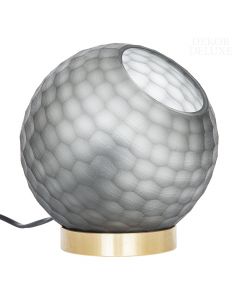 Dekor Deluxe steklena namizna svetilka okrogle oblike z grobo površino v temno sivi barvni na zlatem podstavku.
