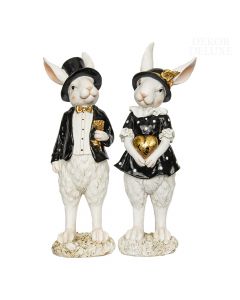 Dekor Deluxe par dveh belih zajčkov iz umetne mase  višine 32 cm z oblačili črne barve in zlatimi dodatki.