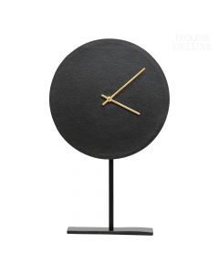 Dekor Deluxe črna namizna kovinska ura minimalističnega izgleda na črnem stojalu z zlatimi kazalci.
