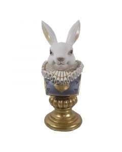 Doprsni kipec belega zajčka z velikim ovratnikom in modro obleko na zlatem valjastem podstavku.